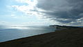 English: The view west from the top of Afton Down, Isle of Wight. Looking west, Freshwater Bay can be seen, and behind that rises Tennyson Down, with its chalk cliffs beside the English Channel. To the right is the Solent (the sea between the Isle of Wight and the mainland), showing how "thin" this part of the island is.