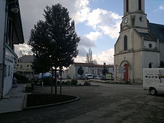 Photo datant de 2013 représentant l'église et la place André Ripoche présentant le même cadrage qu'en 1910