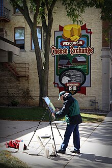 An artist works on his canvas next to one of the Walldogs murals that dot downtown Plymouth. Walldog.jpg