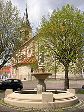 Der Krengeljägerbrunnen, dahinter die Stadtkirche St. Nikolaus