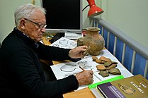 L'archéologue russe Vladislav Ivanovich Mamontov en train d'identifier des céramiques à partir de catalogues de comparaison