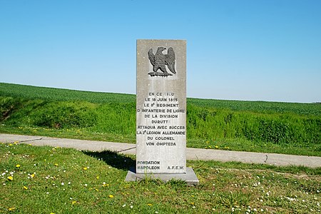 La stèle et le paysage du champ de bataille à Plancenoit.