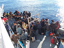 North African immigrants near the Italian island of Sicily Boat People at Sicily in the Mediterranean Sea.jpg