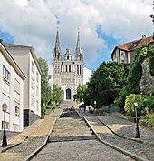 Photographie de la façade d'une cathédrale, un escalier au premier-plan (montée Saint-Maurice).