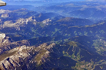 Luftbild der bergigen Gegend mit Fernblick nach Bozen