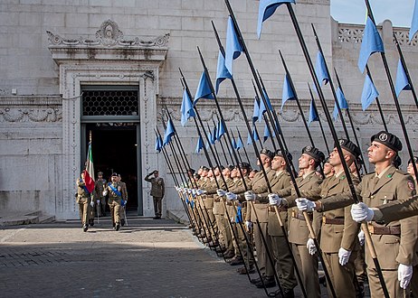 A Regiment "Lancieri di Montebello" (8th) honor guard salutes the flag of the Logistic Regiment "Sassari" as it leaves the Shrine of the Flags