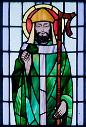 Saint Patrick avec un trèfle à la main sur le vitrail d'une église.