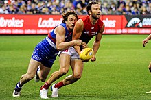 Western Bulldogs player Liam Picken tackling Jordan Lewis of Melbourne, who is attempting a handball Liam Picken tackling Jordan Lewis while handballing.jpg