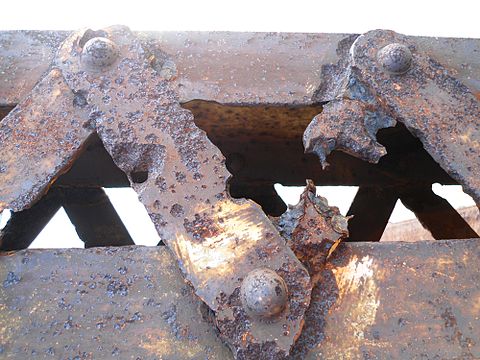 Rusted and pitted struts of the 70-year-old Nandu River Iron Bridge