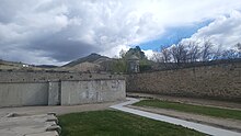 The southeast corner of the penitentiary walls, where the "cooler" is seen in the foreground and Table Rock in the background. OISPcorner.jpg