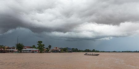 Pirogue sur le Mékong sous de lourds nuages gris pendant la mousson avant une tempête à Don Det. Août 2018.
