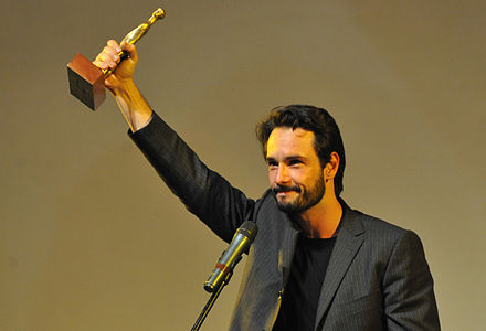 Brazilian actor Rodrigo Santoro lifts a statue he received for the best actor award at the 44th Festival of Brasília for the film My Country, Meu País, by André Ristum.