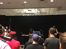 Stemage (semi-hidden on the right) playing guitar at MAGWest 2019 Saori Kobayashi performance at MAGWest 2019 3 of 3.jpg