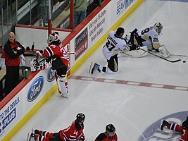 Martin Brodeur estirant-se a la banqueta dels Devils durant els calentaments.