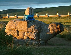 Una delle tartarughe di pietra dell'antica Karakorum; sullo sfondo le mura del monastero di Erdene Zuu