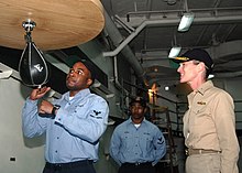 Pottenger in April 2007, watching a sailor hit a punching bag aboard a naval ship. US Navy 070417-N-6710M-031 Information System Technician 3rd Class Anthony Seay demonstrates the proper way to hit a speed bag.jpg