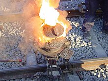 Thermite reaction proceeding in railway welding. Shortly after this, the liquid iron flows into the mould around the rail gap. Velp-thermitewelding-1.jpg