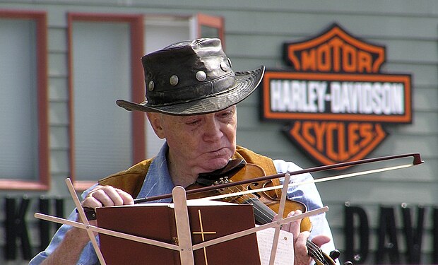 Wayne plays fiddle while Harley idles by, Juneau, Alaska.