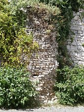 Vue d'un massif de maçonnerie plaqué contre un mur en moyen appareil