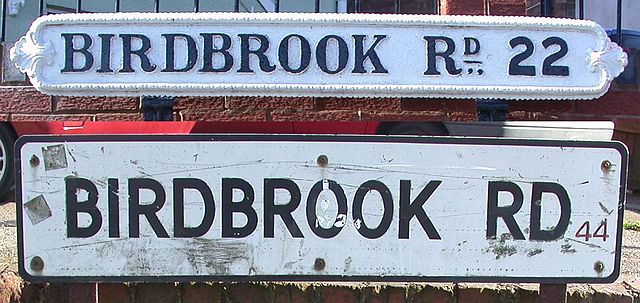 Street name signs on Birdbrook Road, Great Barr, Birmingham, showing old "Birmingham 22" postal district (top) and modern "B44" postcode.