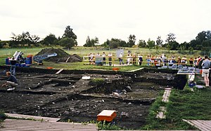 People observing archaeological excavation