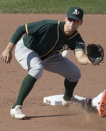 A baseball player in dark green and gray