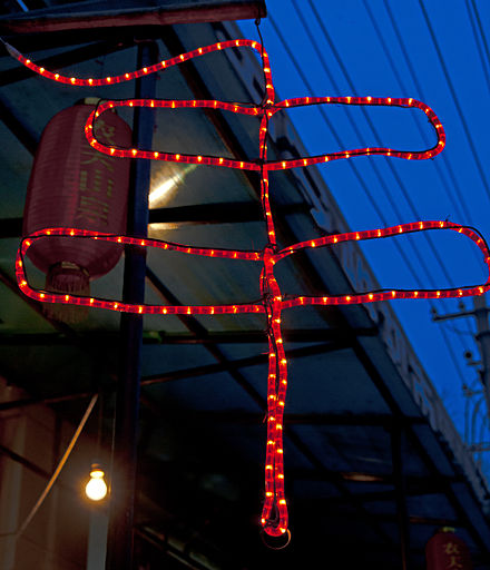 Illuminated version of the chuan character outside a shop selling it, found all over the city