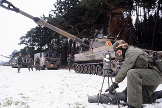 A soldier of the 2nd Battalion, 27th Field Artillery setting up a collimator to sight in a howitzer during Exercise Reforger '85, with an M109A2 self-propelled howitzer in the background DF-ST-85-13333 Soldier setting up a collimator to sight in a Howitzer during REFORGER '85.png