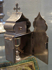 Small tabernacle for the communion of the sick. At the top is a box for the Reserved Mysteries (Reserved Sacrament), at the bottom, is a small chalice, and in the back is a tiny communion spoon with a cross on the handle (Kiev-Pecherski Lavra) Daronositsa kiev.jpg