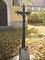Železný kříž před vchodem do kaple
