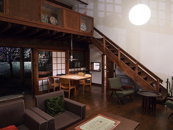 Double-height living room area featuring furnishings and lighting designed by Maekawa