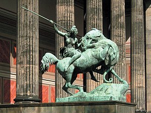 Скульптура обнаженной женщины с копьем на коне. Большая кошка (пантера или лев) нападает на лошадь.