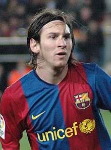 Close-up of a long-haired young man, wearing a football shirt with blue and red vertical stripes