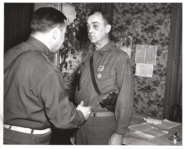 Major General Leland S. Hobbs presents the Legion Of Merit to Brigadier General James M. Lewis, commander of the 30th Division Artillery, for his meri