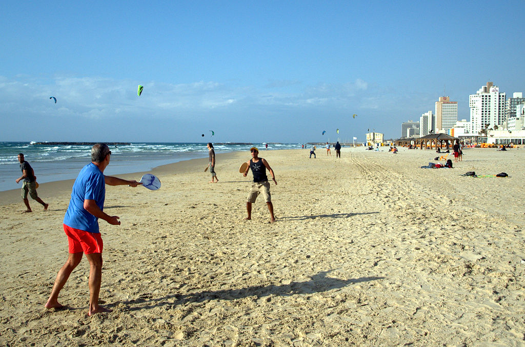 people playing paddle tennis on the beach