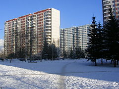 Barres d'immeubles blanches à une dizaine d'étages. Il fait beau et le sol est couvert de neige.