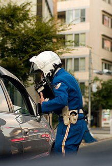 A Japanese prefectural police motorcycle officer questioning a motorist during a traffic stop Motorcycle cop interview.jpg