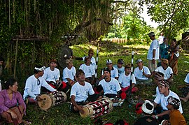 A gamelan Belenganjur player playing for the procession and cremation (ngaben) ceremony in Bali, Indonesia. Musicians for the procession and cremation ceremony Bali Indonesia.jpg