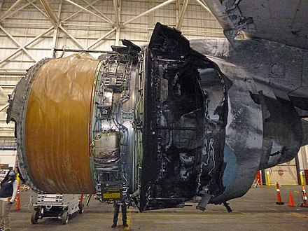 Inboard side of the right engine of UAL328 showing the exposed fan containment wrap (brown) and fire damage to the thrust reversers (NTSB photo)