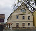 Bauernhof mit Wohnstallhaus, Scheune (oben verbrettert), Hofpflasterung, Hofmauer und Torpfeilern