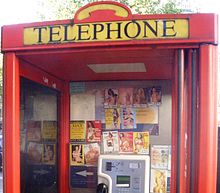 Tart cards in a British phone box advertising the services of call girls Phone box prostitute calling cards 1 crop.jpg