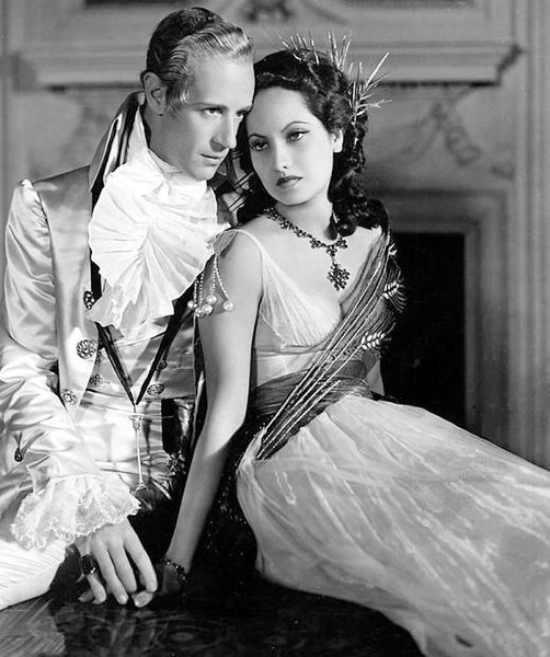 Howard as Sir Percy Blakeney (alter ego of the Scarlet Pimpernel) next to Merle Oberon as Lady Blakeney in The Scarlet Pimpernel (1934)