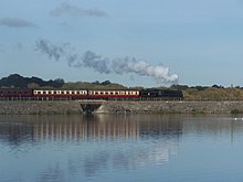 The Midland Railway – Butterley's mainline steam locomotive, ex-British Rail 4-6-0 Class 5MT 73129 crossing the stone causeway over Butterley Reservoir