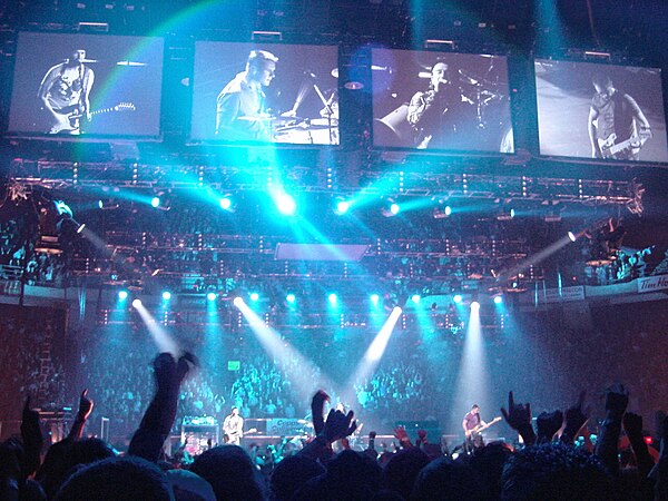 Four video screens above the front of the stage displayed camera feeds dedicated to each band member.