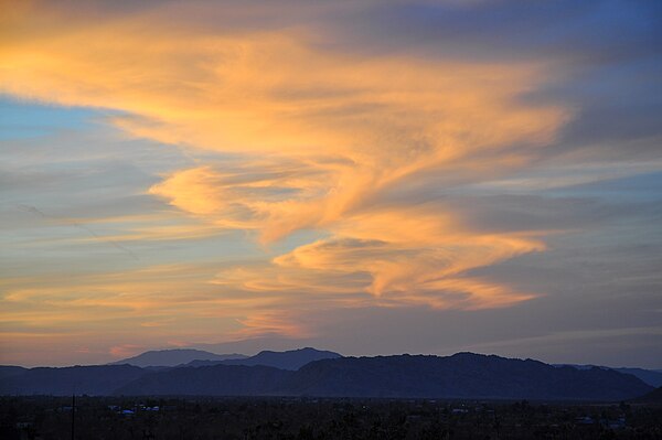 A Kármán vortex street is demonstrated in this photo, as winds from the west blow onto clouds that have formed over the mountains in the desert. This 