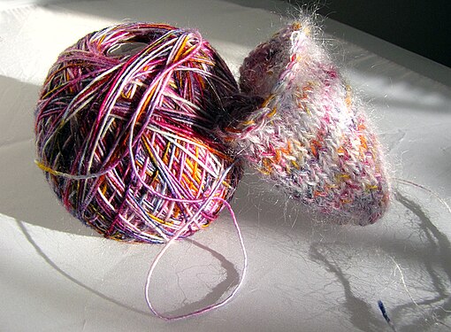 Wool ball with a little knitted piece in the evening sun light