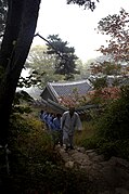 Monk and Templestay guests walk up a wooded path in the temple (2008)