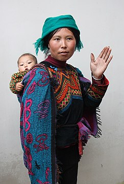 Yi woman in traditional dress with a child