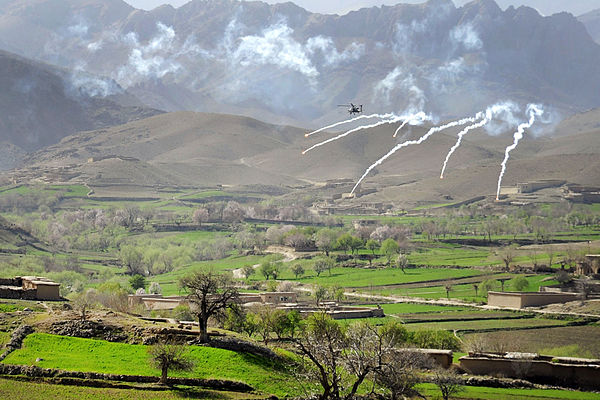 An AH-64 Apache helicopter shoots flares over a valley to support members of the 8th Commando Kandak and coalition special operations forces during a 