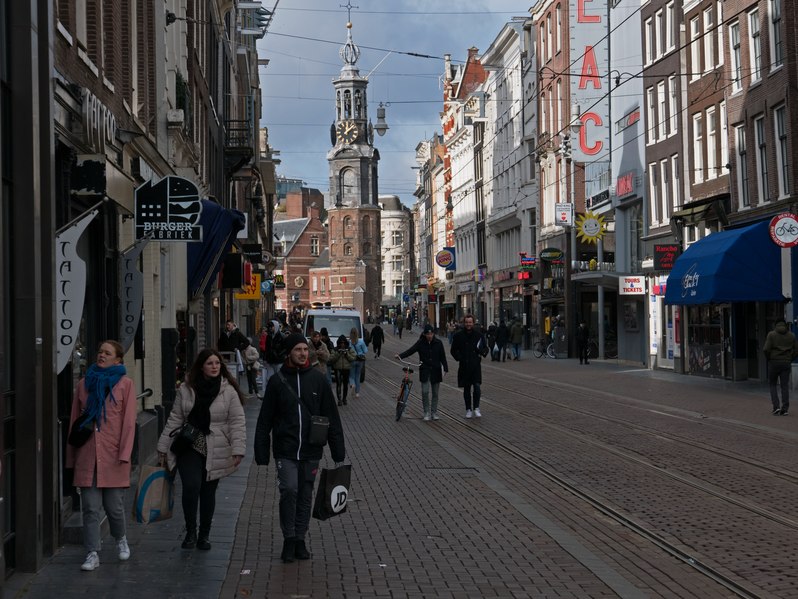 File:A street view of people walking in the Reguliersbreestraat in Amsterdam old city with in the background the old city tower Munttoren. Free photo by Fons Heijnsbroek, 19 February 2022.tif